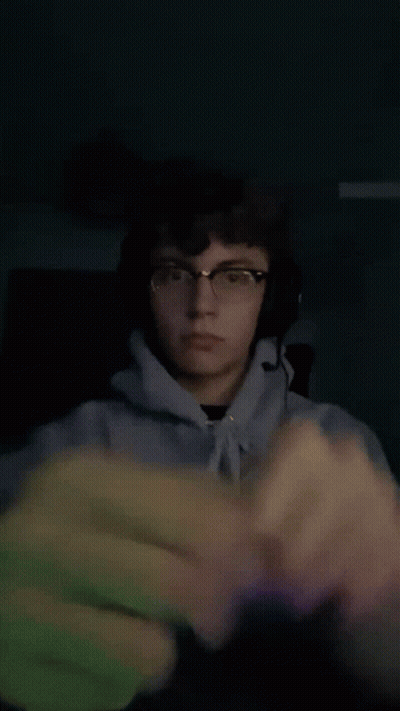 Young Man With Glasses And Headphones Holding Fist GIF