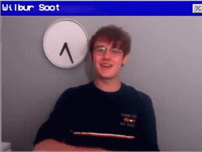 Young Man With Glasses Beside Clock GIF
