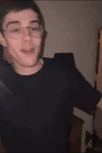 Young Man With Glasses In Black Shirt Making Funny Face GIF