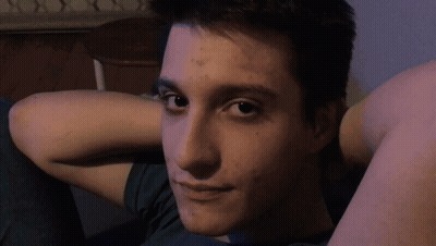 Young Man With Hands Behind Head In Green Shirt GIF