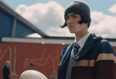 Young Man With Hat Tie Holding Rugby Ball GIF