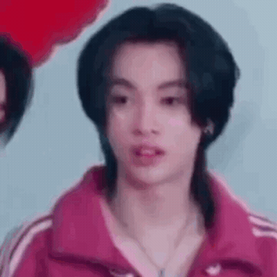 Young Man With Long Black Hair In Pink Jacket And Necklace GIF