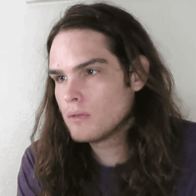 Young Man With Long Hair And Purple Shirt GIF