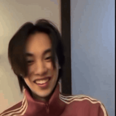 Young Man With Long Hair In Red Adidas Jacket Smiling GIF