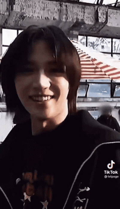 Young Man With Long Hair Smiling In Black Jacket GIF
