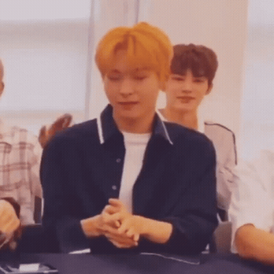 Young Man With Orange Hair Sitting With Folded Hands GIF