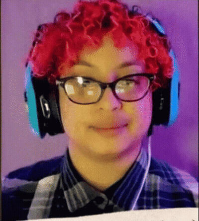 Young Man With Red Curly Hair and Glasses Wearing Headphones