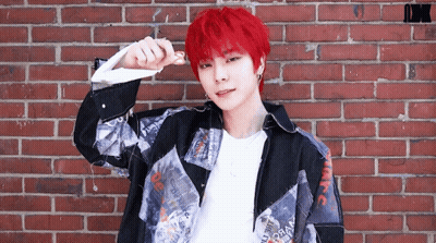 Young Man With Red Hair In Front Of Brick Wall GIF
