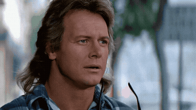 Young Man With Red Hair In Sweater Vest And Tie GIF