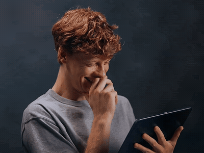 Young Man with Red Hair Laughing Holding Tablet