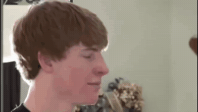Young Man With Red Hair Standing In Front Of Mirror GIF