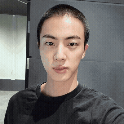 Young Man With Shaved Head Looking At Camera GIF