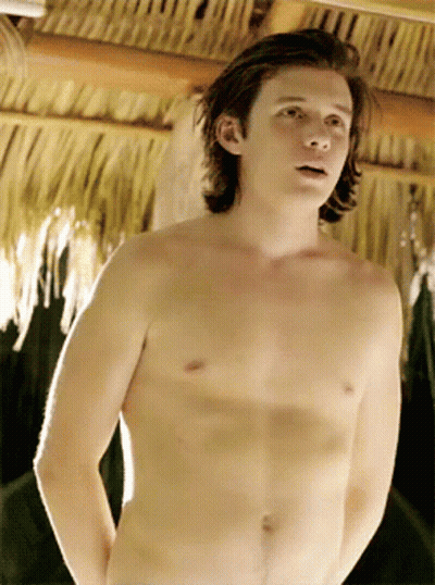 Young Man Without Shirt In Front Of Thatched Roof GIF