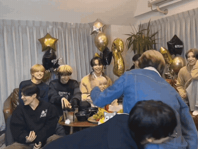 Young Men Around Table With Black Gteam Balloon GIF