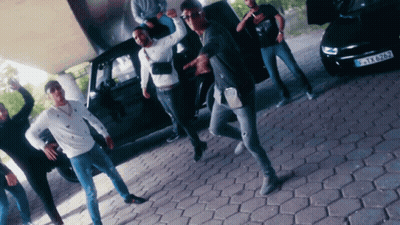 Young Men Dancing In Front Of Black Car GIF