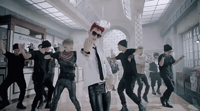 Young Men Dancing In Front Of Exchange Sign GIF