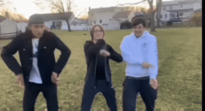Young Men Dancing In Grassy Field GIF