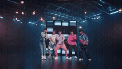 Young Men Dancing On Stage In Front Of TV Wall GIF