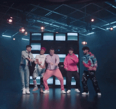 Young Men Dancing On Stage In Front Of Wall Of Televisions GIF