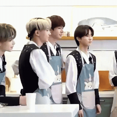 Young Men In Aprons Talking In Kitchen GIF