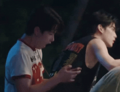 Young Men In Dark Room One Holding Soda GIF