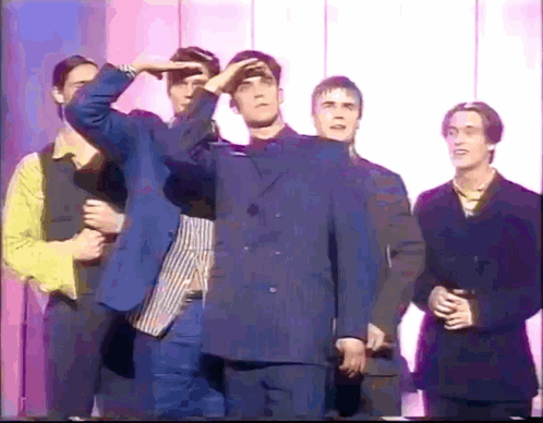 Young Men In Suits In Front Of Wall GIF