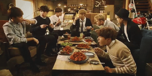Young Men Sitting Around Food GIF