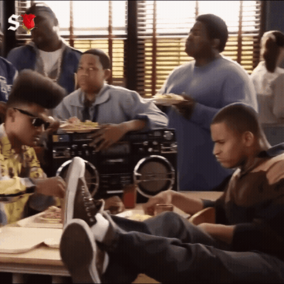 Young Men Sitting Around Table With Feet Up GIF