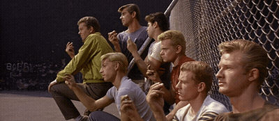 Young Men Sitting In Front Of Chain Link Fence With Borg Graffiti GIF