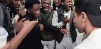 Young Men Standing Around Man In Hat GIF