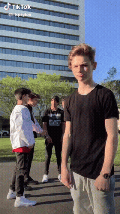 Young Men Standing In Front Of Building With TikTok GIF