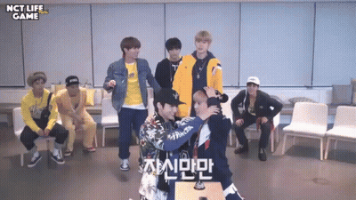 Young Men Standing in Room With NCT Life Game