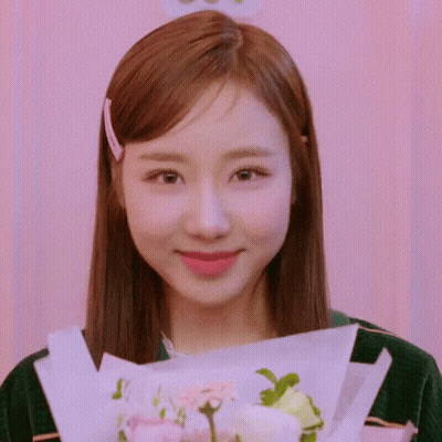Young Woman Holding Flowers And Smiling GIF