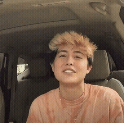 Young Woman In Back Seat With Tie Dye Shirt And Necklace GIF