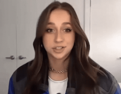 Young Woman In Blue Jacket Talking To Camera GIF