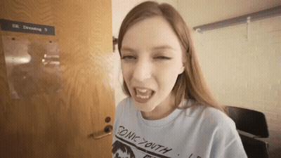 Young Woman In Blue Sonic Youth Shirt At Door GIF