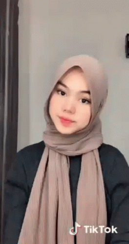 Young Woman In Hijab And Scarf Looking At Camera GIF