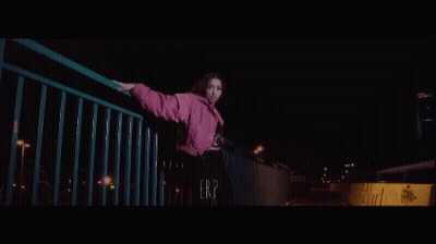 Young Woman In Pink Jacket On Bridge At Night GIF