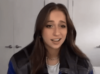 Young Woman In Plaid Jacket Talking To Camera GIF