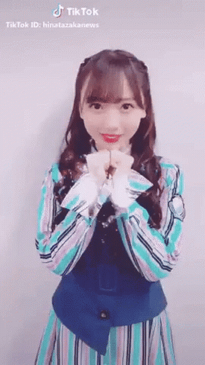 Young Woman In Striped Dress Making Heart Shape With Hands GIF
