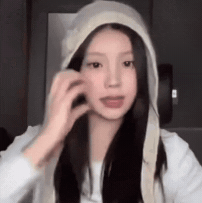 Young Woman In White Hoodie Touching Hair GIF