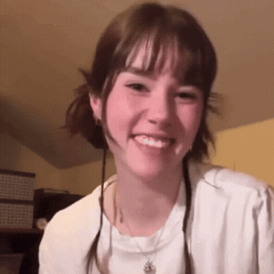 Young Woman In White Shirt And Necklace Smiling GIF