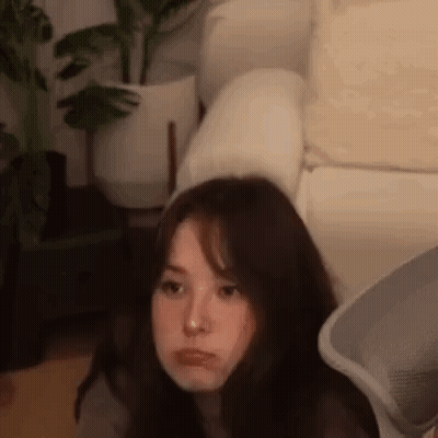 Young Woman Sitting On Couch In Living Room GIF
