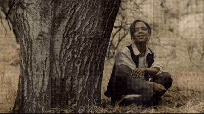Young Woman Sitting Under Tree In Woods GIF
